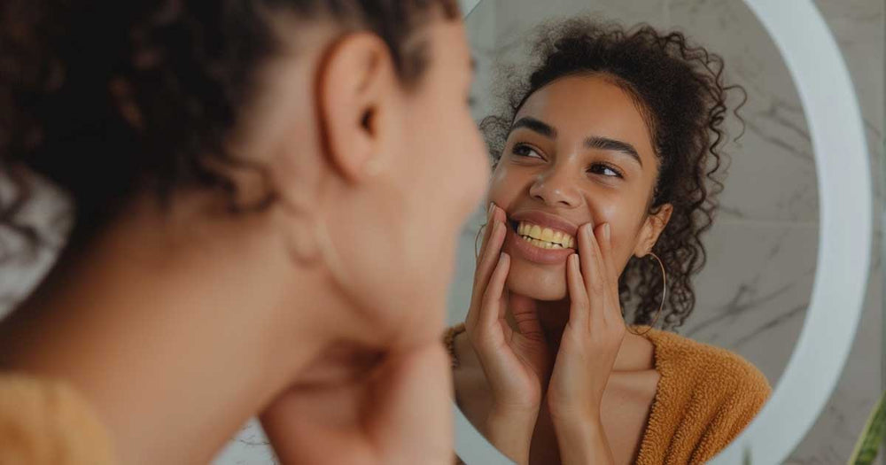 An ethnic woman looking at her yellow teeth in the mirror