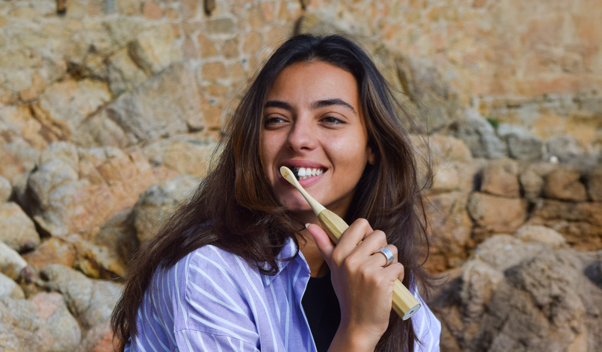 A women using the Zen Bamboo Electric Toothbrush